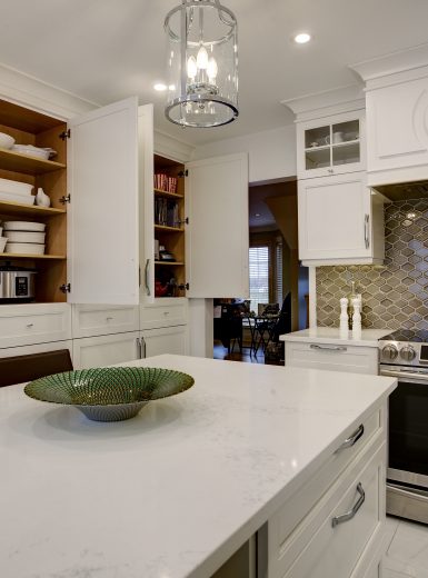 classic kitchen, white cabinets, glass pendants, caesarstone counters, .wine cellar, mosaic backsplash
