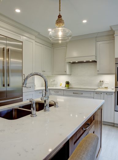 classic kitchen, white cabinets, walnut cabinets, glass pendants, caesarstone counters, island